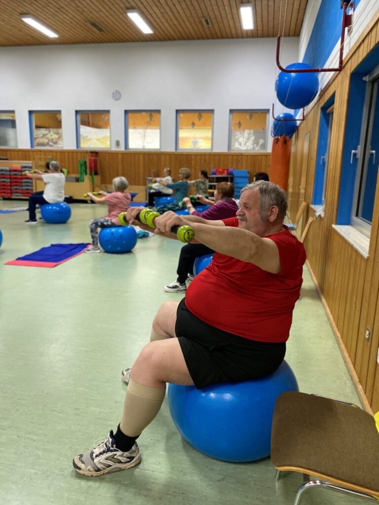 <strong>Das neue Rehasport-Buch mit Interviews und Praxisbeispielen</strong> 2 AC Forst Rehasportler mit Hanteln auf Pezziball - <strong>Das neue Rehasport-Buch mit Interviews und Praxisbeispielen</strong>