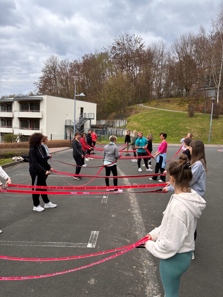 Rückblick Netzwerktreffen März 2026: Der "bewegte Weg zur Achtsamkeit" im Rehasport 11 Outdoor Partneruebung Kraeftigung Schulter mit Band - Rückblick Netzwerktreffen März 2026: Der "bewegte Weg zur Achtsamkeit" im Rehasport